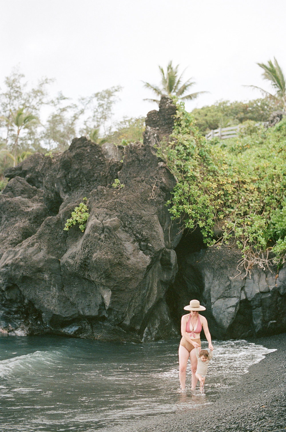 Family travel inspiration in Maui, Hawaii on a black sand beach.